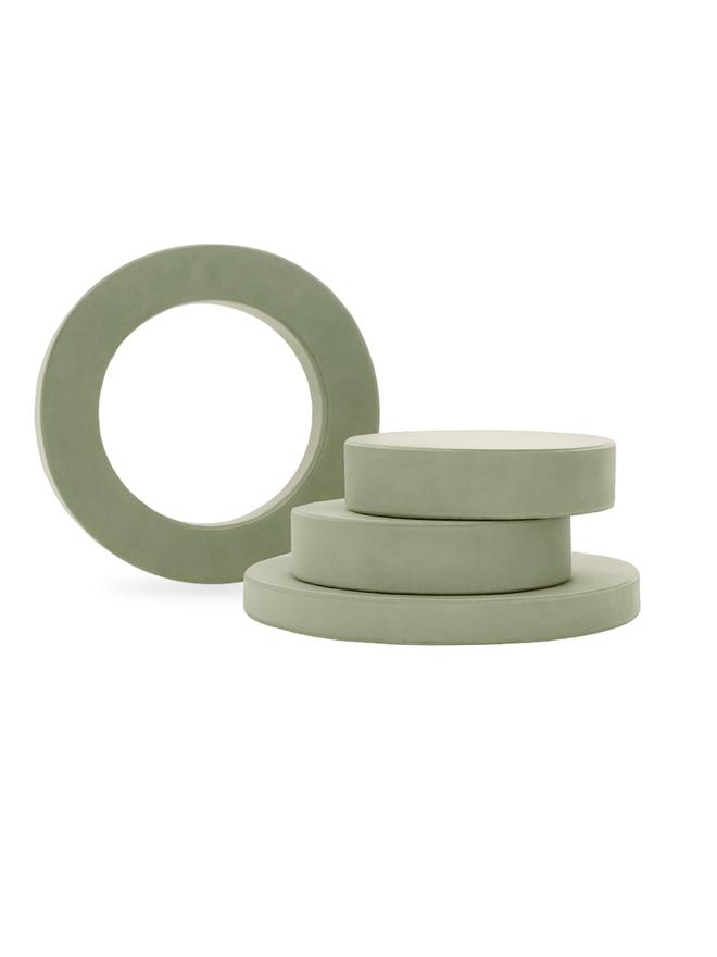 Whottie ottoman pieces in sage green. Stacked in a tower, side view of modular play furniture for kids